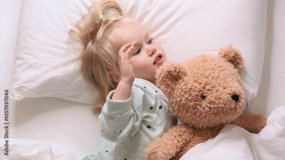 Little child toddler girl goes to bed hugging a toy bear. Little child toddler girl goes to bed hugging a toy bear.