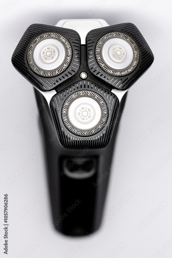 Beard electric shaver on a white background. Close-up of the cutting blades. Photo taken in artificial light with clearly visible details of the shaver