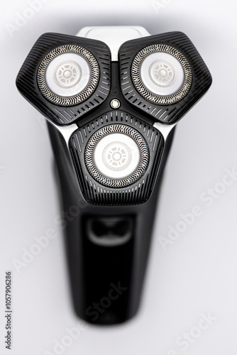 Beard  electric shaver on a white background. Close-up of the cutting blades. Photo taken in artificial light with clearly visible details of the shaver