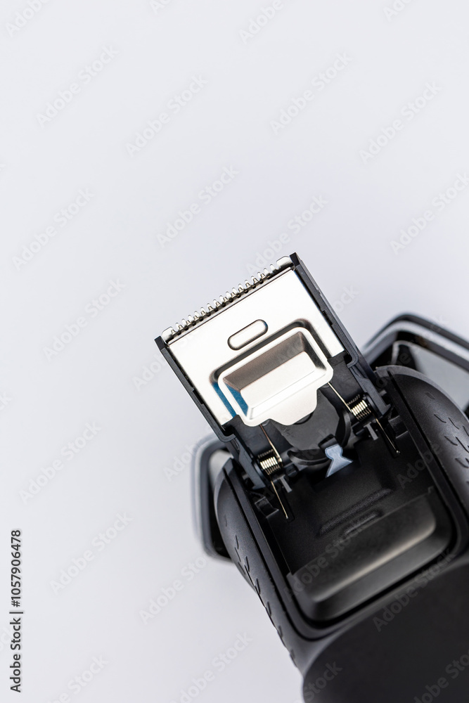Beard shaver on a white background. Macro close-up of the trimming cutting blades. Photo taken in artificial light with clearly visible details of the shaver