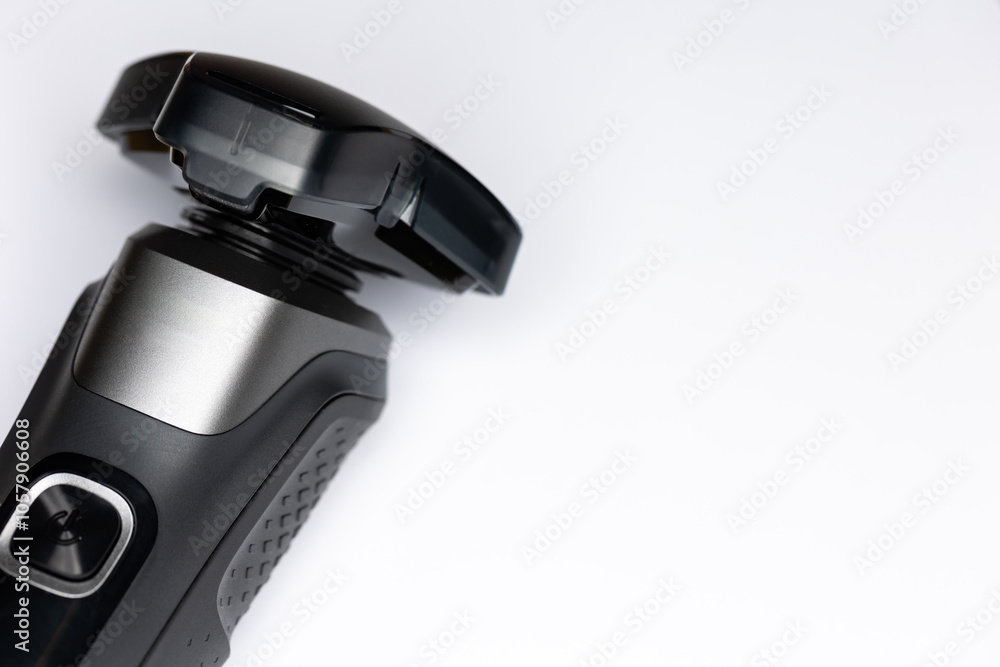 Beard shaver on a white background. Cutting blades protected by plastic cover. Photo taken in artificial light with clearly visible details of the shaver