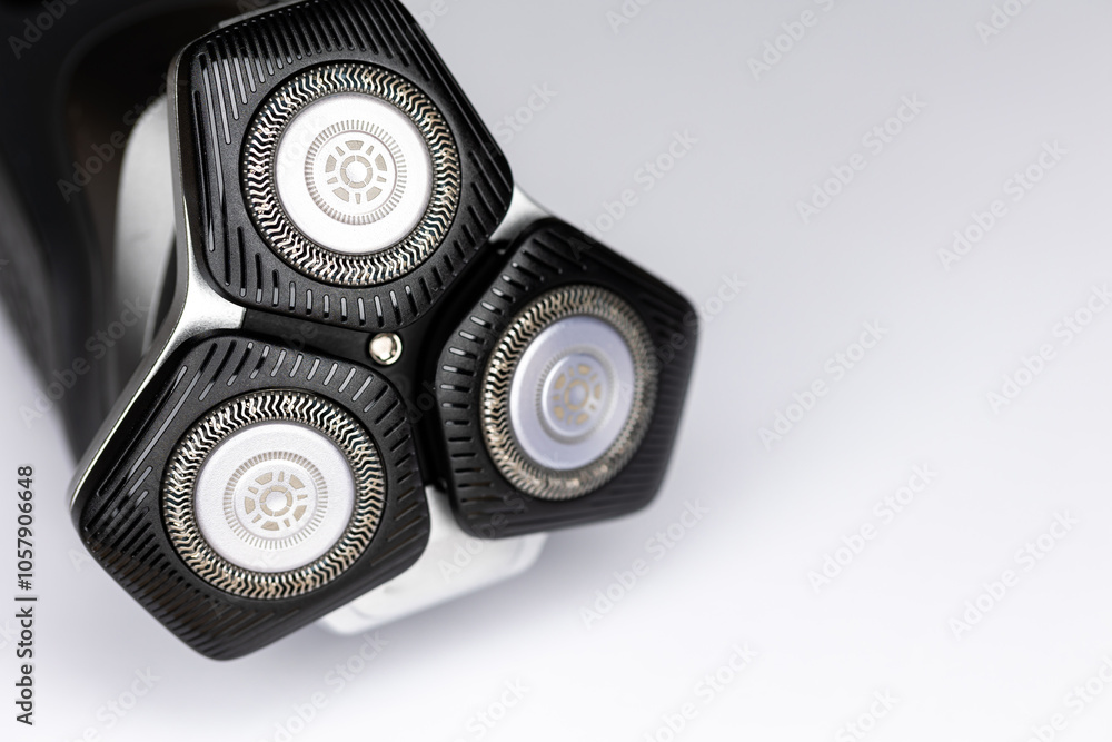 Beard electric shaver on a white background. Close-up of the cutting blades. Photo taken in artificial light with clearly visible details of the shaver