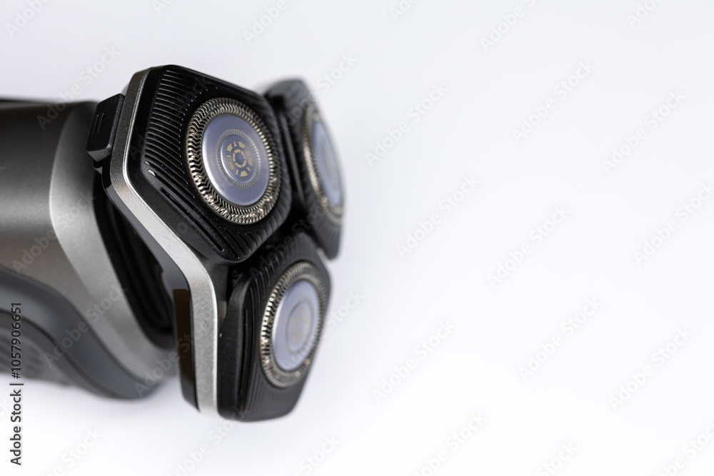 Beard electric shaver on a white background. Close-up of the cutting blades. Photo taken in artificial light with clearly visible details of the shaver