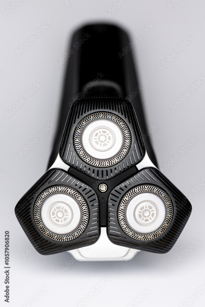 Beard electric shaver on a white background. Close-up of the cutting blades. Photo taken in artificial light with clearly visible details of the shaver