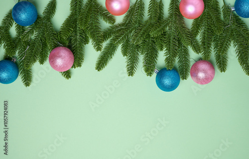 Shiny pink and blue balls and green fir branches on green background, Christmas background photo