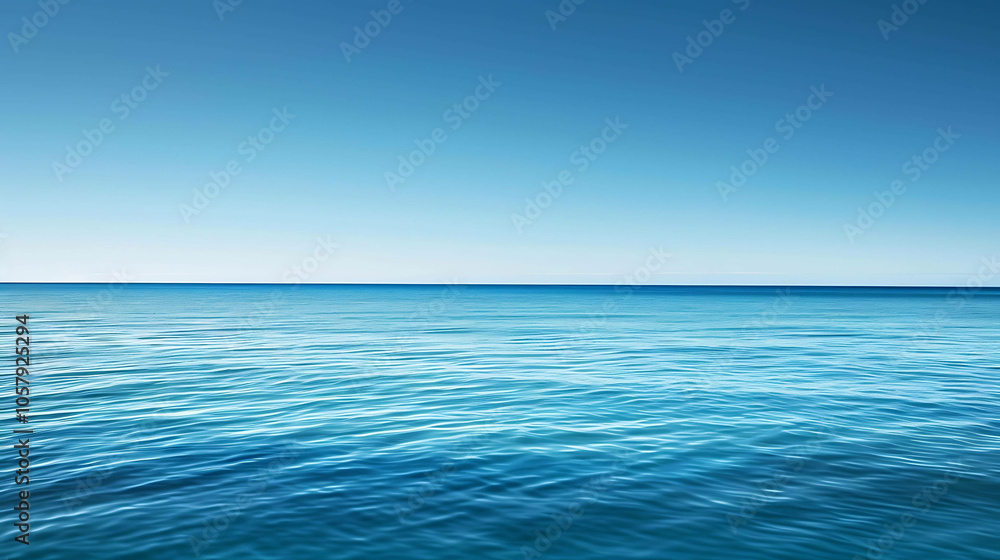 Fototapeta premium Deep blue ocean with a clear blue sky. The water is calm and still, with small waves rippling on the surface.