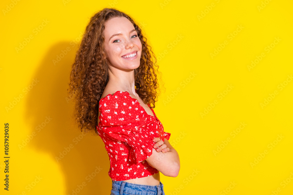 Photo portrait of pretty young girl profile crossed hands confident wear trendy red outfit isolated on yellow color background Photo portrait of pretty young girl profile crossed hands confident wear trendy red outfit isolated on yellow color background