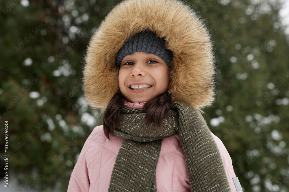 Portrait of smiling young girl wearing pink winter jacket outdoors and looking at camera in snowy forest Portrait of smiling young girl wearing pink winter jacket outdoors and looking at camera in snowy forest