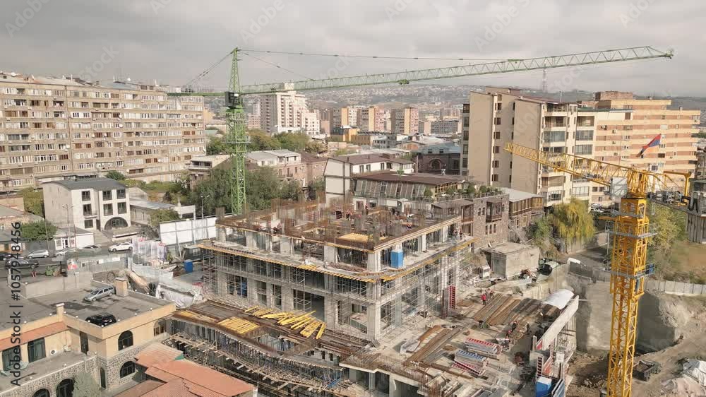Aerial panning view construction site with crane cary block material and workers working on site. Real estate property business in kantron district. Yerevan capital investments concept Aerial panning view construction site with crane cary block material and workers working on site. Real estate property business in kantron district. Yerevan capital investments concept