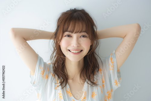 頭の上で手を組んでいる女性 photo