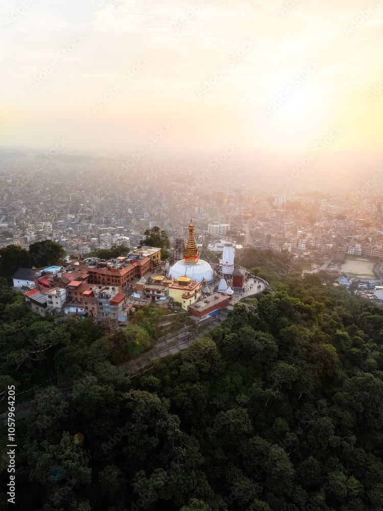 Fototapeta premium Aerial drone view of Swoyambhu Mahachaitya aka the Monkey Temple — an ancient religious complex atop a hill in the Kathmandu Valley, west of Kathmandu city at sunrise.