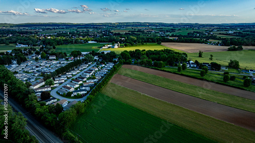 Fototapeta Naklejka Na Ścianę i Meble -  Residential Mobile, Manufactured, Prefab, Home Park with many houses and trees. The houses are white and the trees are green. The sky is cloudy and the houses are spread out