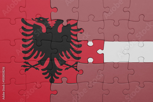 puzzle with the colourful national flag of albania and flag of latvia .