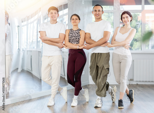 Group of young men and women dancing folk dance in row in studio photo