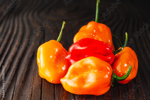 Superhot Habanero Peppers: Fresh and Spicy Chili with Ingredients on a Wooden Background photo