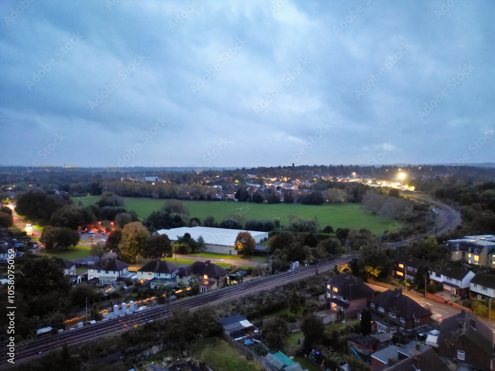 Fototapeta premium Aerial Footage of Illuminated Residential District Homes at Central Hitchin Town of England Great Britain. The Footage was Captured with Drone's Camera on October 28th, 2023 During Night.