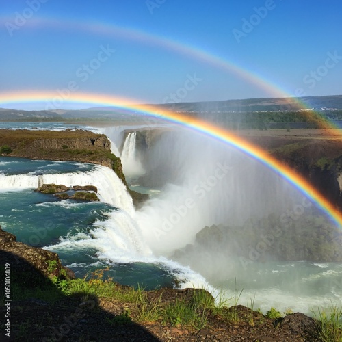 Majestic waterfall with a double rainbow arching across the mist 