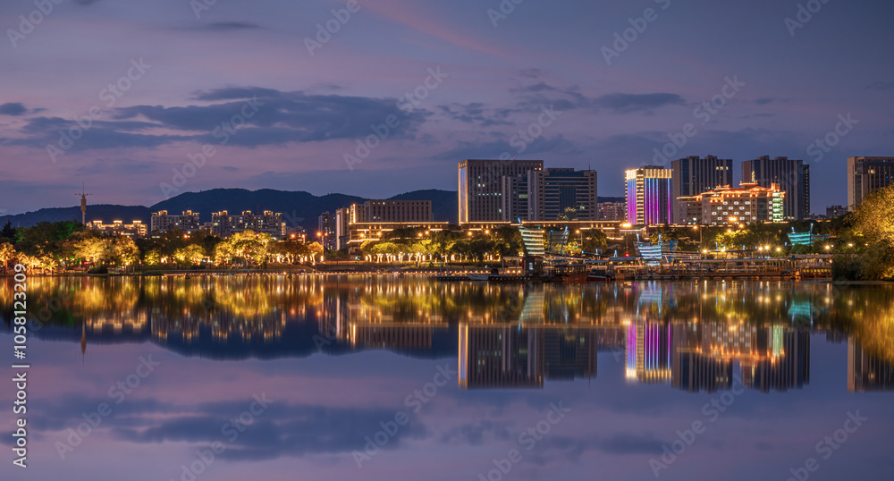 Vibrant Cityscape at Night with Reflective Water and Illuminated Buildings Vibrant Cityscape at Night with Reflective Water and Illuminated Buildings