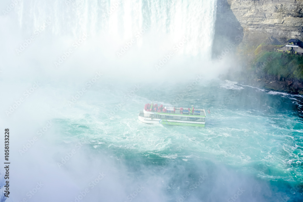 Naklejka premium Beautiful autumn day at Niagara Falls, America. Maid of the Mist boat in the water. Rainbow in front of boat.
