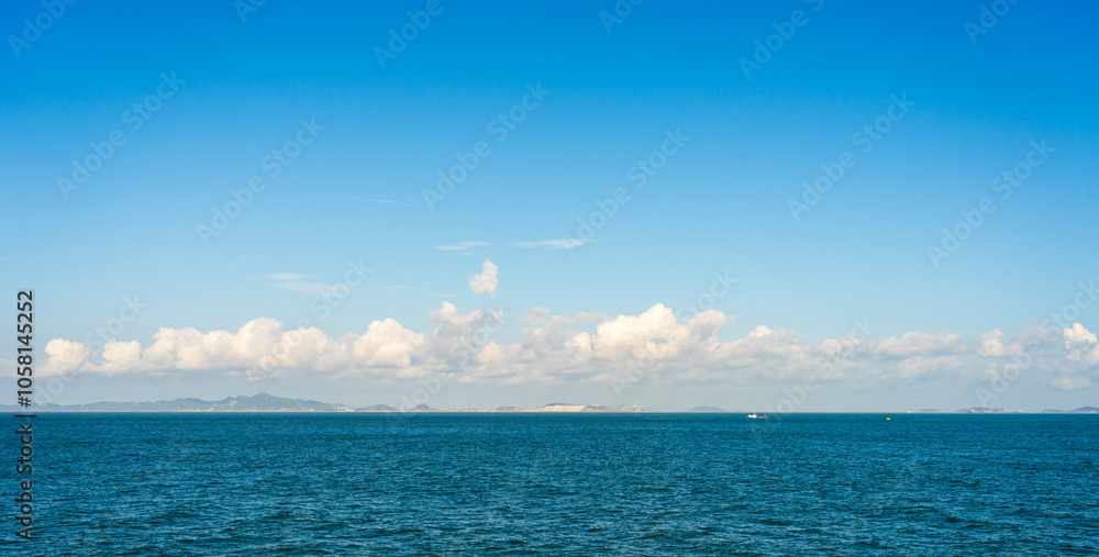 Obraz premium Serene Ocean View Under a Clear Blue Sky with Diffused Clouds