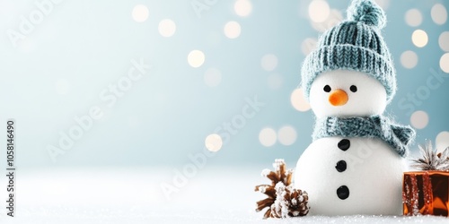 A cheerful snowman with a blue hat and scarf stands on snow beside a wrapped gift, embodying festive joy and winter magic amid sparkling lights backdrop. photo