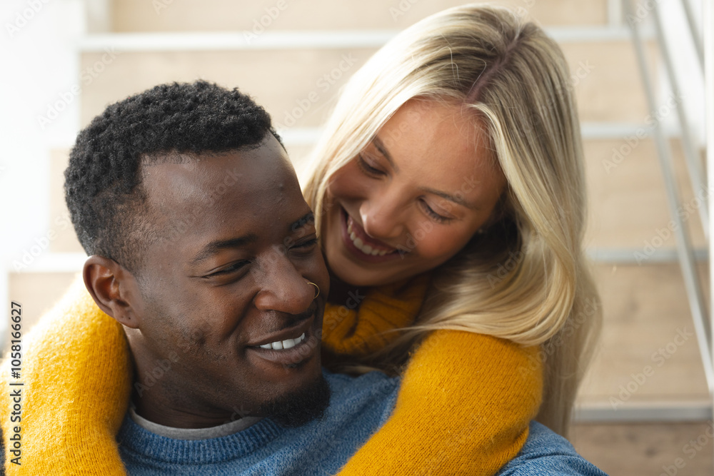 Happy multiracial couple embracing on staircase, enjoying cozy holiday moment together, at home Happy multiracial couple embracing on staircase, enjoying cozy holiday moment together, at home