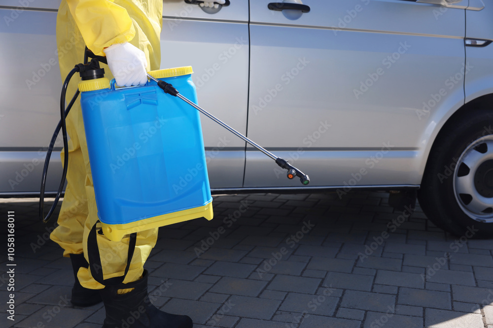 Pest control worker with spray tank near gray minibus outdoors, closeup Pest control worker with spray tank near gray minibus outdoors, closeup