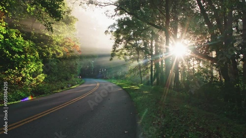 A car passes down a country road with a foggy sunrise in Spruce Pine, North Carolina