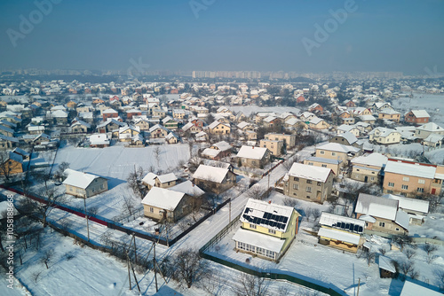 Aerial view of residential houses with snow covered roofops in suburban rural town area in winter photo