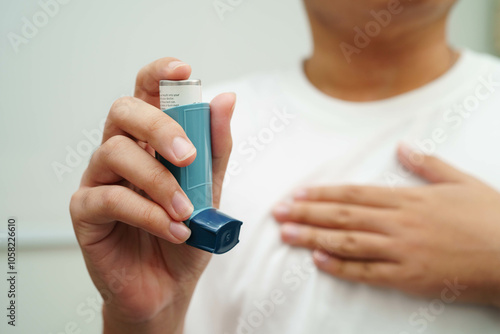 Asthma and chronic obstructive pulmonary disease COPD, Asian young man using metered dose inhaler MDI. photo