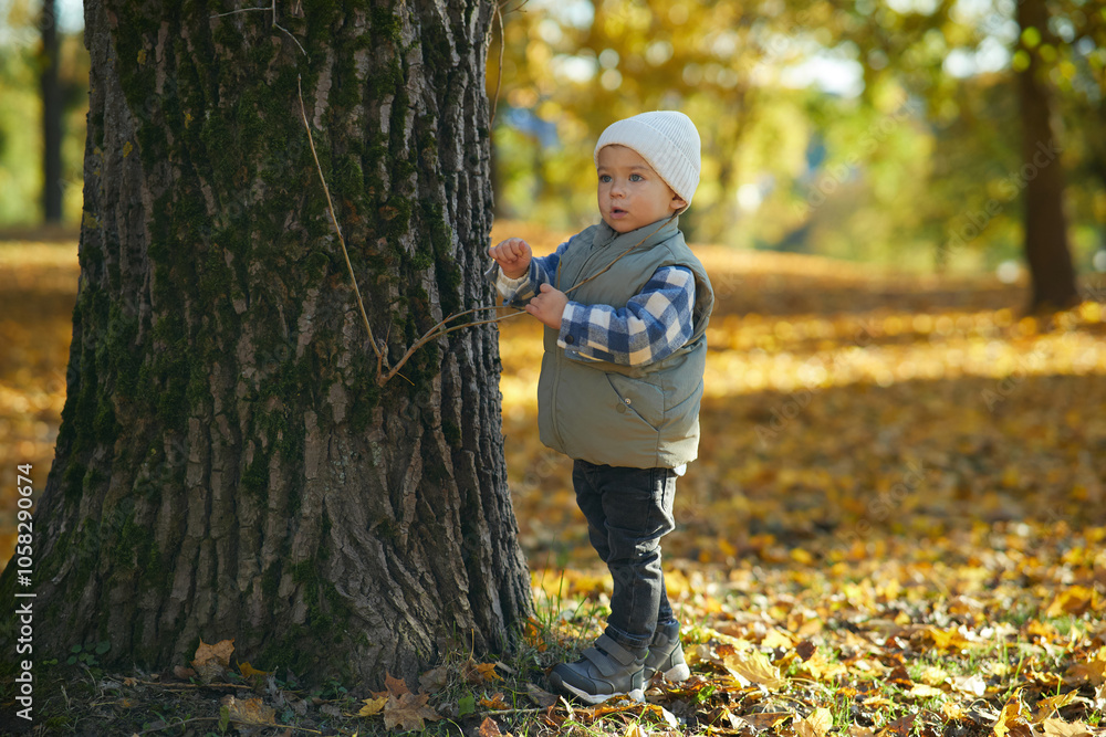 A toddler sits on autumn leaves, wearing a cozy beanie and warm vest, surrounded by fall foliage. The child's curious gaze captures the innocence and beauty of the autumn season outdoors. A toddler sits on autumn leaves, wearing a cozy beanie and warm vest, surrounded by fall foliage. The child's curious gaze captures the innocence and beauty of the autumn season outdoors.