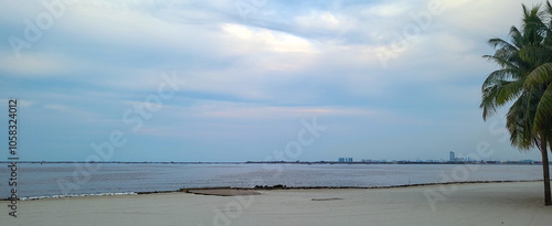 Beach guardrail with wood and rope at Pantai Indah Kapuk with calm water view in the background.  photo