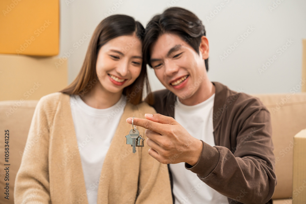 The couple asian family buying new house. Holding key Make a sale and purchase agreement with a real estate agent rent or purchase apartment home. Moving relocation with parcel box cardboard The couple asian family buying new house. Holding key Make a sale and purchase agreement with a real estate agent rent or purchase apartment home. Moving relocation with parcel box cardboard