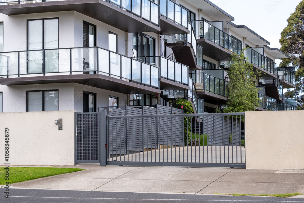Ταπετσαρία Modern apartment complex featuring multiple balconies with glass railings and a metal gated entrance