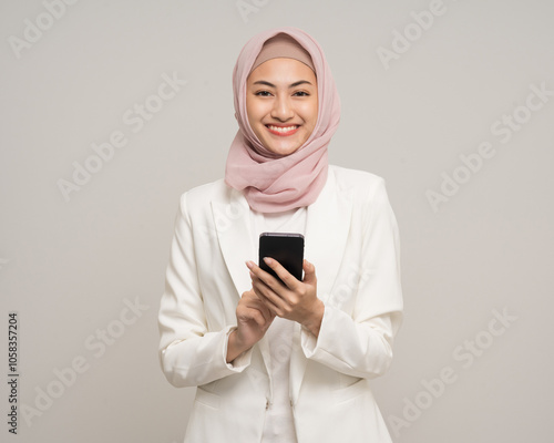 Portrait happy young asian business muslim woman holding smartphone standing on isolated white background. Business Attractive Muslim woman wearing abaya and hijab fashion costume