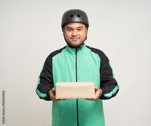 Young asian rider wearing green jacket uniform and bike helmet various action holding paper parcel box delivery to customer. Delivery man service worker Courier and shipping parcel cardboard service. photo