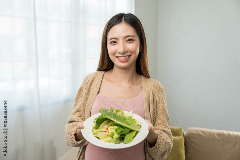 Happy pregnant woman eating vegetable salad and smiling to camera, concept of healthy mother taking health care and nourish her fetal and waiting her childbirth. Happy pregnant woman eating vegetable salad and smiling to camera, concept of healthy mother taking health care and nourish her fetal and waiting her childbirth.