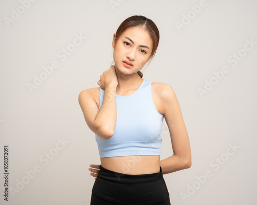 Young sporty asian woman has inflamed neck and backache because she is workout exercise too much. Accident suffering while training workout. She massage to soothe and relax on isolated background.