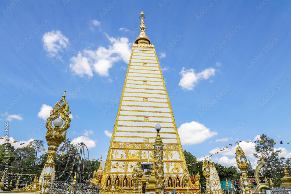 Fototapeta premium Wat Phra That Nong Bua, Ubon Ratchathani, inside there is the Phra That Sri Maha Bodhi Chedi, a replica of the Chedi in Bodh Gaya, India, stucco sculptures, candles, and two large Naga statues.