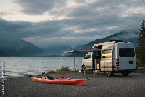 Van parked at a lakeside campsite with a kayak ready for adventure photo