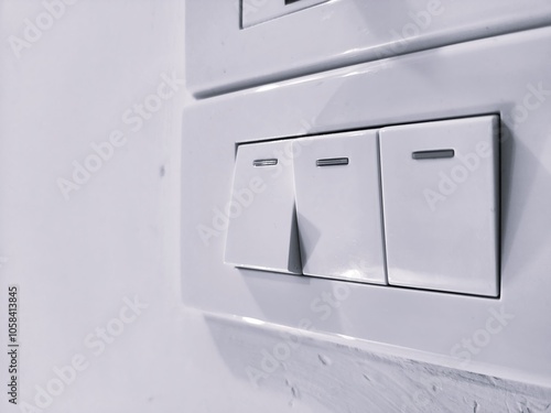 Close-up of Three White Light Switches on a Wall