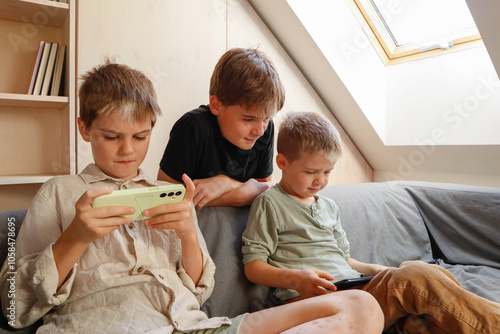 Siblings - family fun on the sofa with technology photo