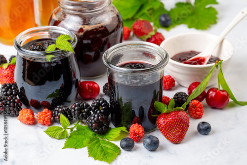 Fresh berries and jar of a ...