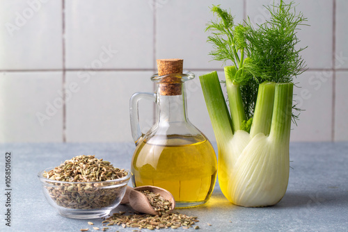 A bottle of fennel essential oil with fresh green fennel twigs and fennel seeds - Fennel oil