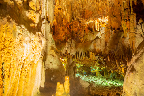 Stone formations on surfaces inside Damlatas Cave (Alanya, Turkey) with orange-yellow illumination. Natural abstract texture of stone patterns photo