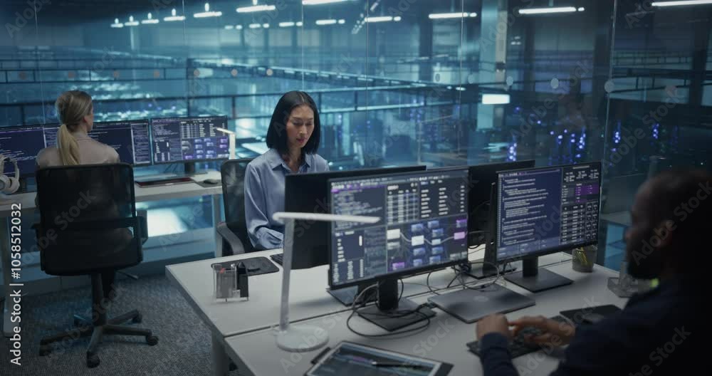 In a Data Center Office With Glass Walls, Diverse Female and Male Team Members Focus on Their Desktop Computers, Conducting Routine System Checks and Working on Network Improvements In a Data Center Office With Glass Walls, Diverse Female and Male Team Members Focus on Their Desktop Computers, Conducting Routine System Checks and Working on Network Improvements