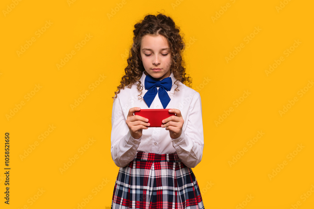 Girl using red smartphone, focused expression Girl using red smartphone, focused expression