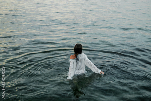 photoshoot of a girl wearing a wet white shirt and underwear on the sea