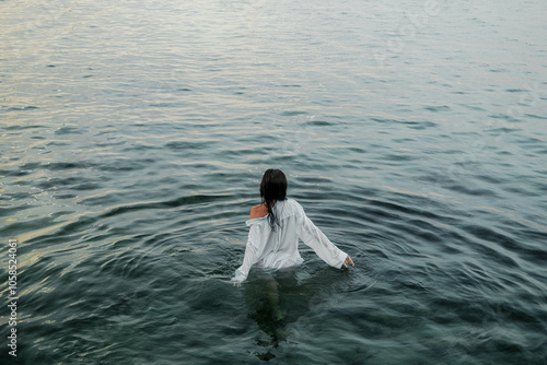 photoshoot of a girl wearing a wet white shirt and underwear on the sea