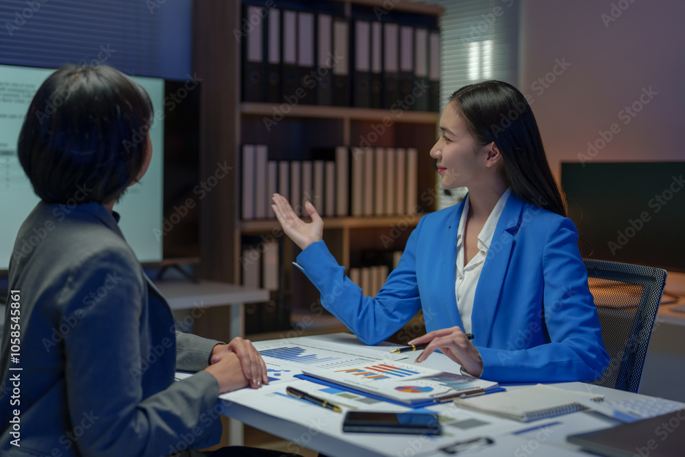 Two Asian businesswomen come up with an idea. Discuss investment projects and strategic planning with information via various documents and files. On a laptop computer at modern office. Two Asian businesswomen come up with an idea. Discuss investment projects and strategic planning with information via various documents and files. On a laptop computer at modern office.